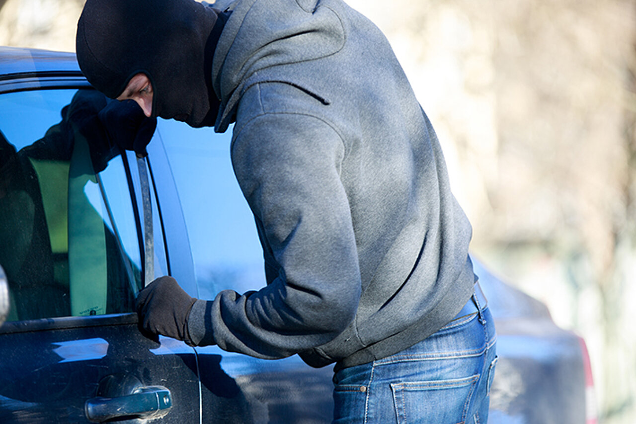 Vermummte Person bricht in Auto ein